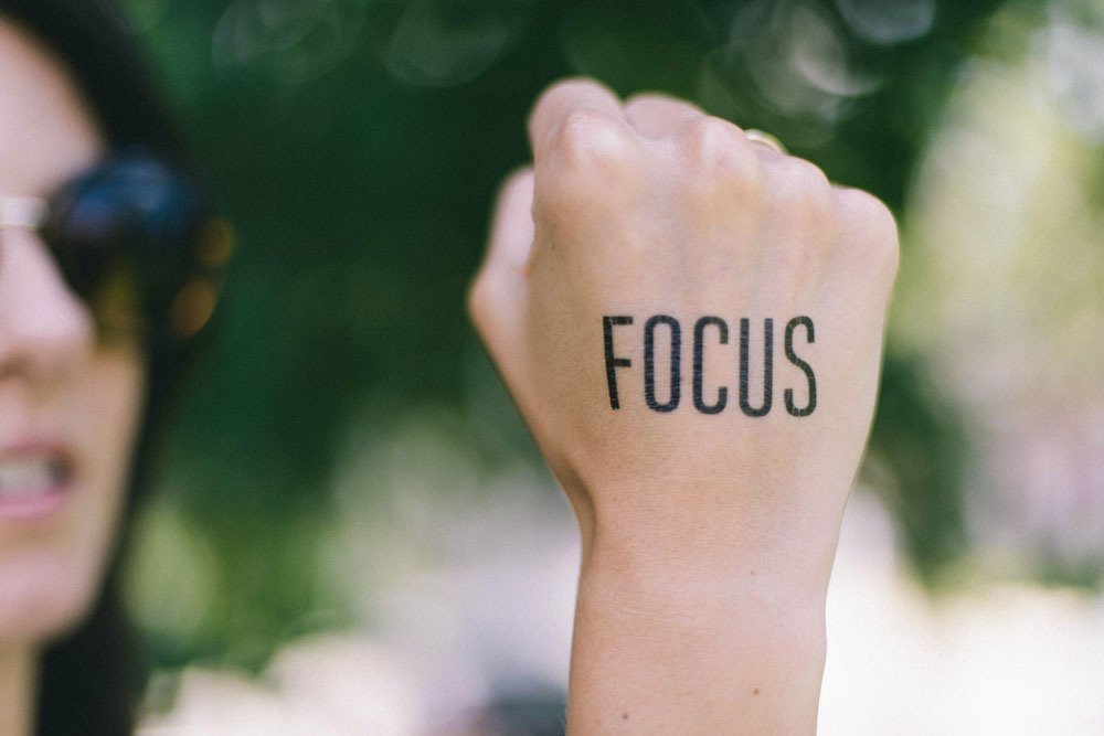 woman making a fist with text tattoo that says focus