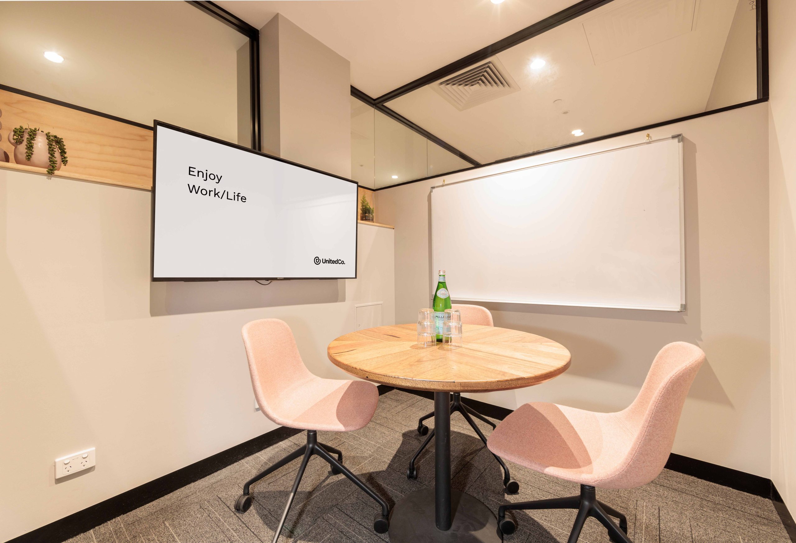 Small meeting room in melbourne seating 3 people with a whiteboard and tv screen